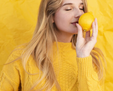 medium shot woman smelling lemon medium shot woman smelling lemon