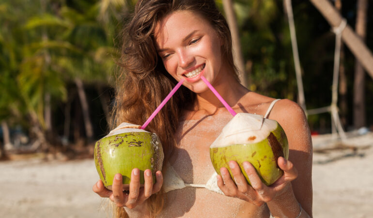 young skinny woman white bikini swimwear holding coconuts smiling sunbathing tropical beach young skinny woman white bikini swimwear holding coconuts smiling sunbathing tropical beach