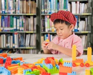 boy playing with plastic blocks library room school boy playing with plastic blocks library room school