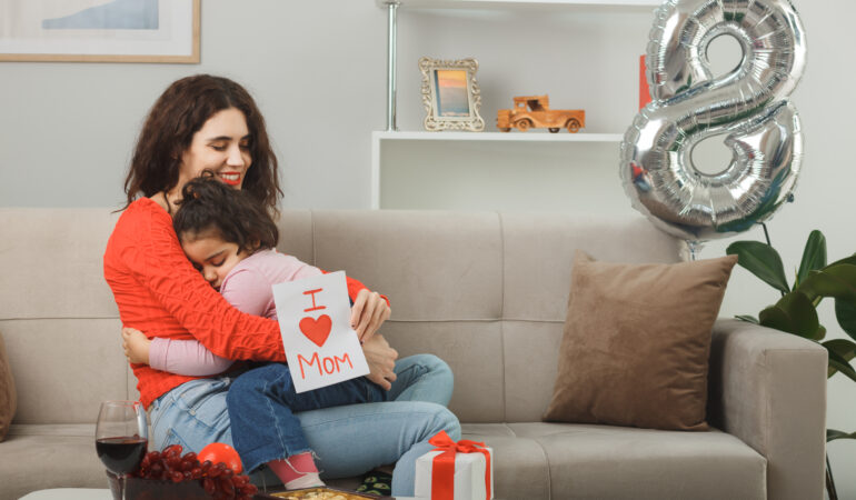 happy mother with her little child daughter sitting couch holding greeting card smiling cheerfully light living room celebrating international women s day march 8 happy mother with her little child daughter sitting couch holding greeting card smiling cheerfully light living room celebrating international women s day march 8